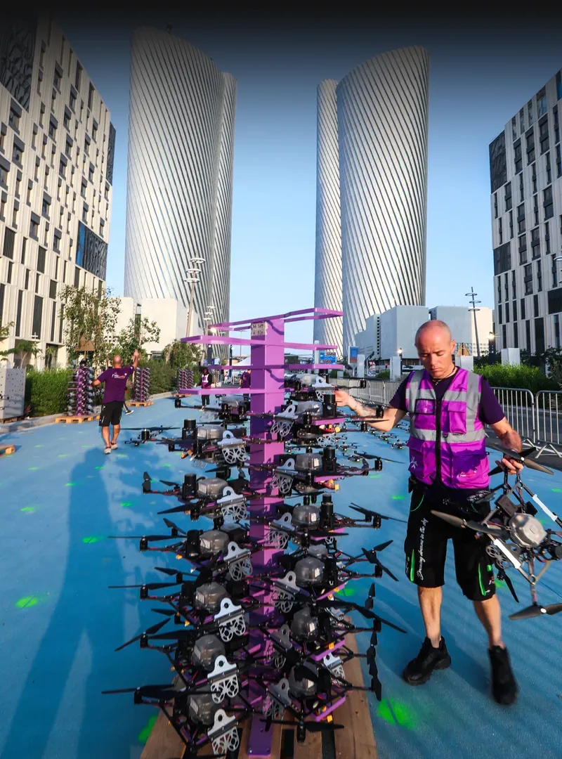 Technicians preparing drones for an outdoor show during the day